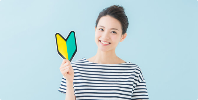 初心者マークを持った笑顔の女性